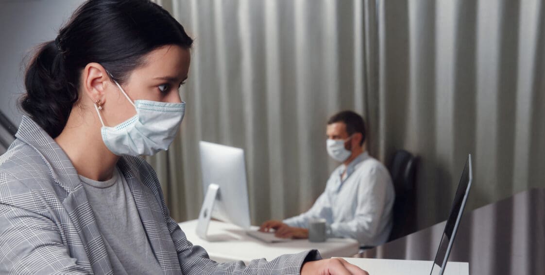 Employees working in business office while wearing medical face mask for protecting and preventing the infection of corona virus disease or covid-19
