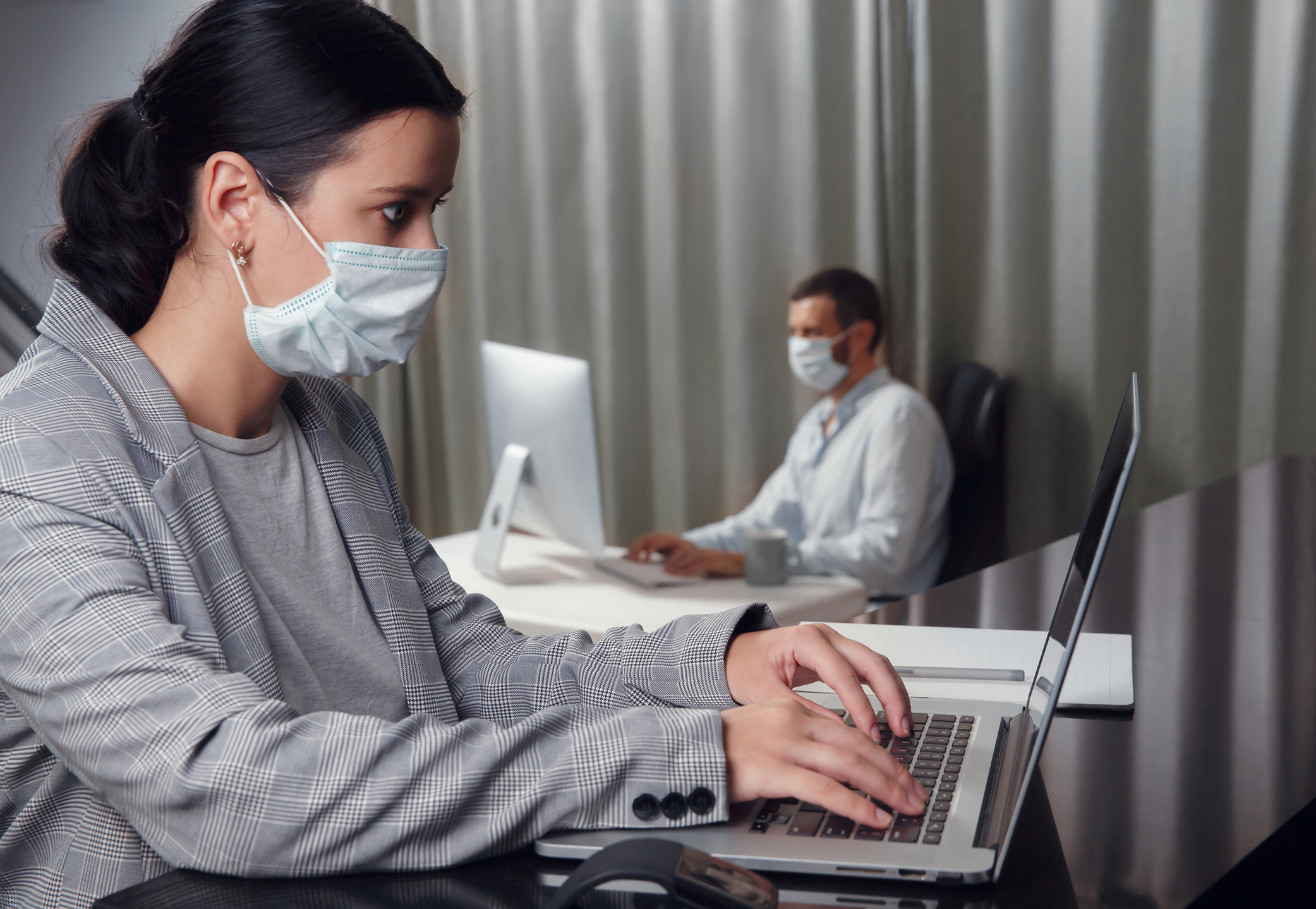 Employees working in business office while wearing medical face mask for protecting and preventing the infection of corona virus disease or covid-19