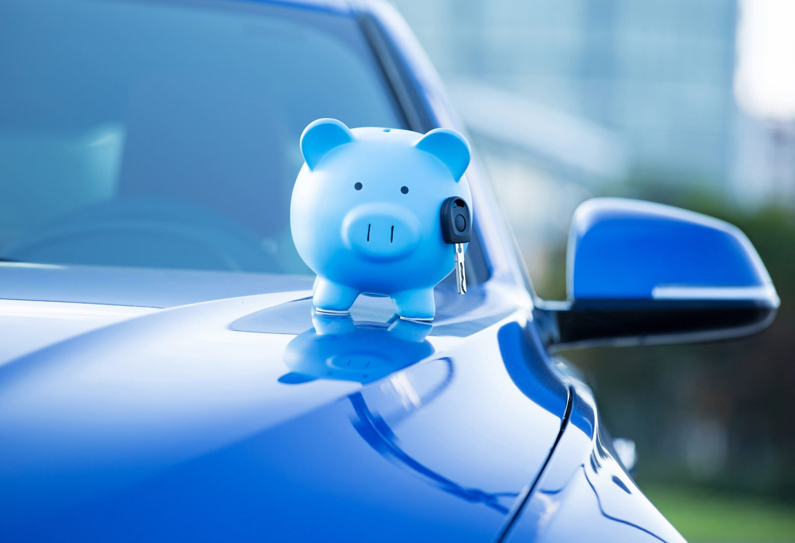 blue piggy bank on blue car waiting to be filled by the $400 refund checks from MCCA to Michigan drivers