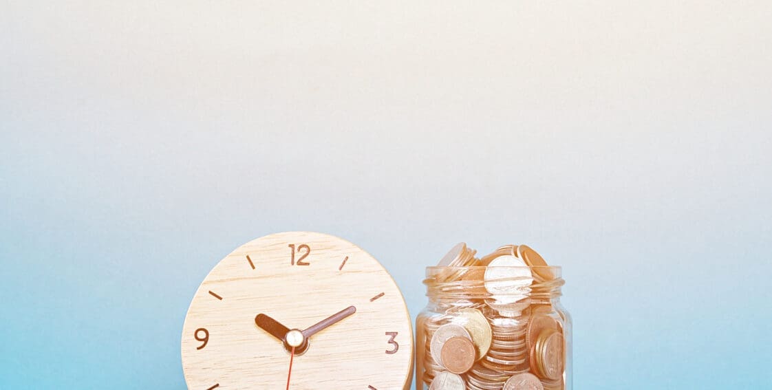 white clock next to jar of money for buy now pay later concept