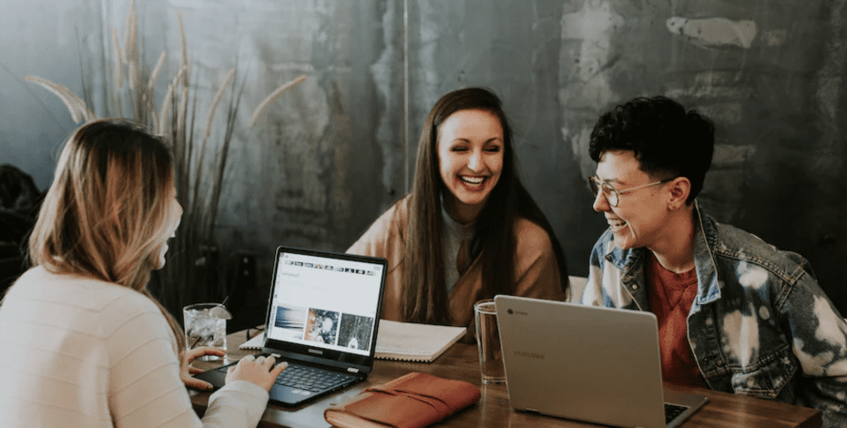 Happy employees laughing while working in a cafe