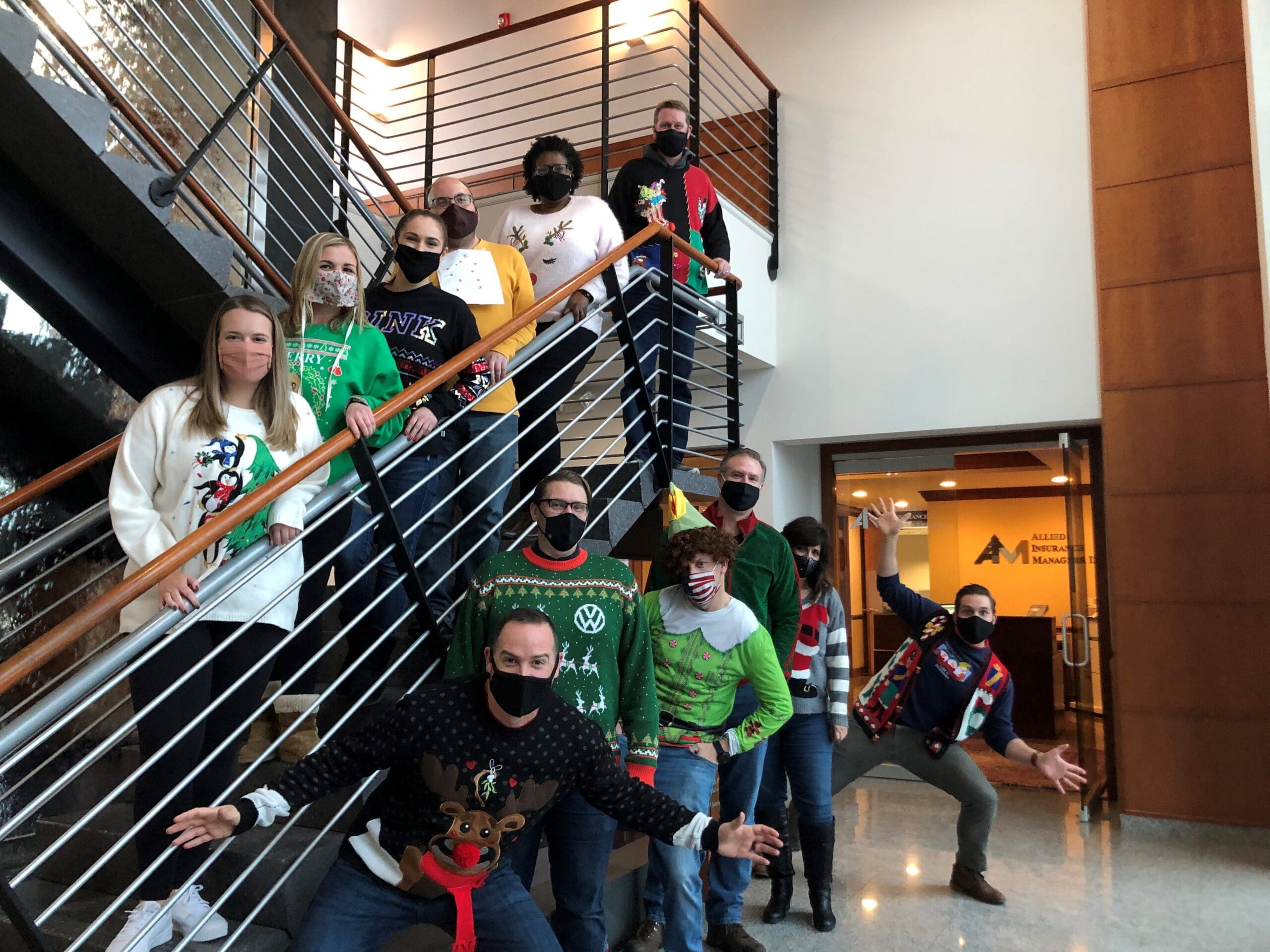 Group of people posted for photo in Christmas sweaters