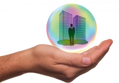 Hand holding business man in bubble