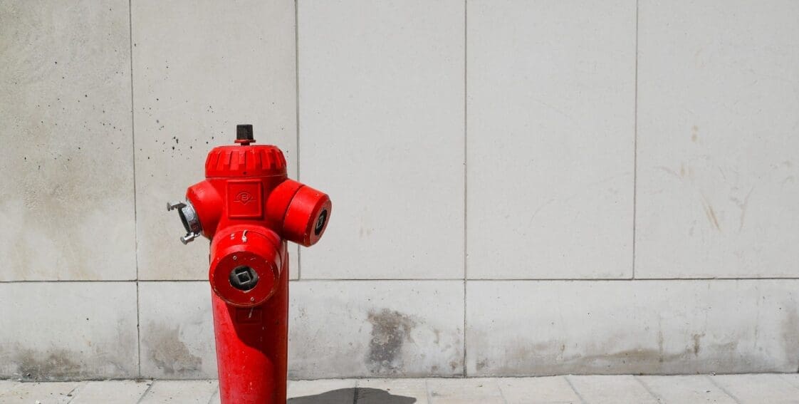 red fire hydrant on sidewalk for fire safety