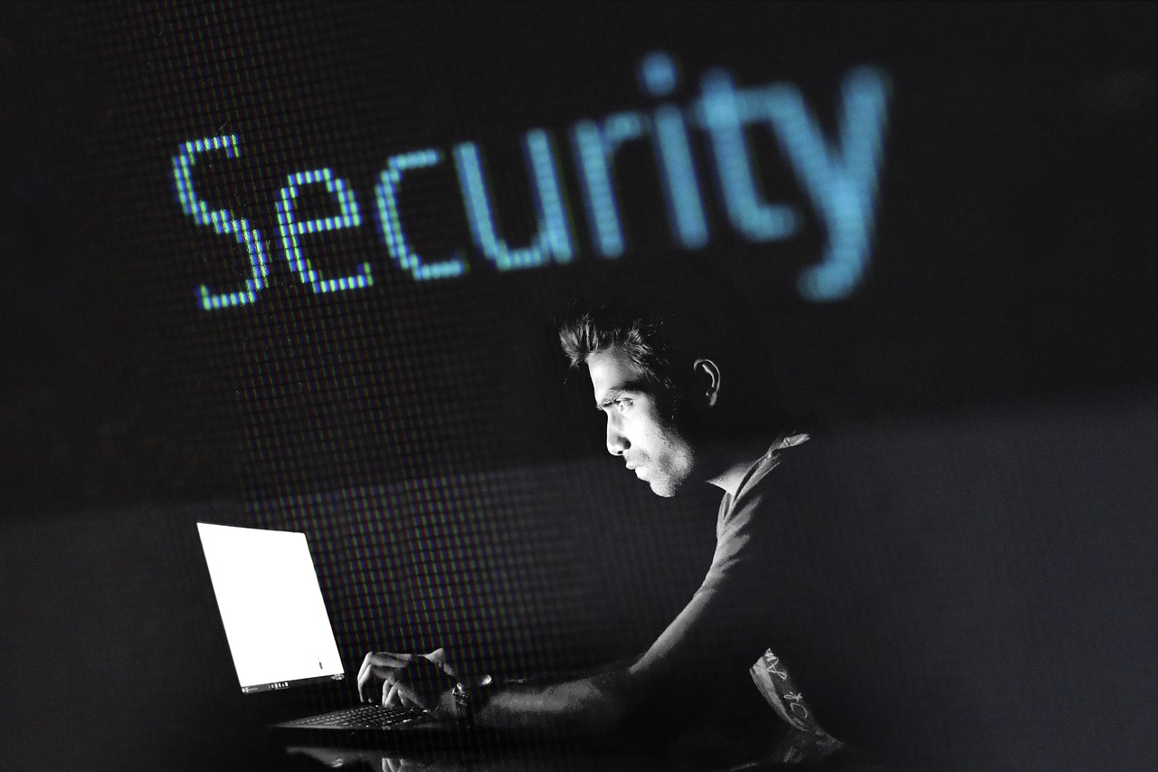 Man looking at computer screen with the word "Security" above him