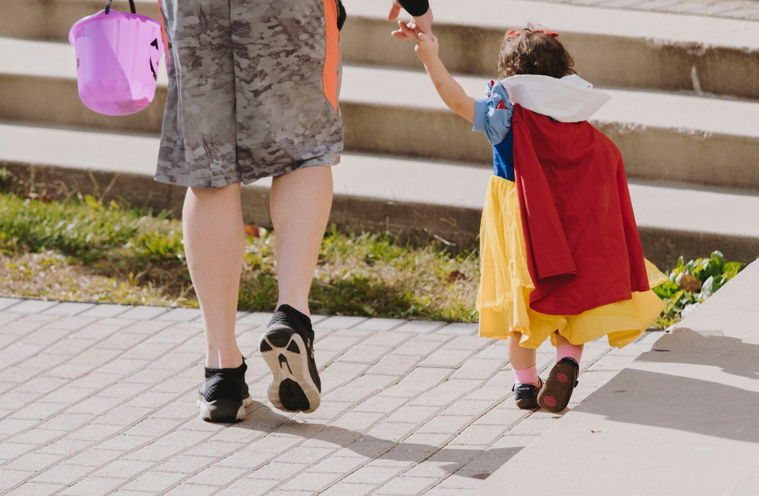 Little girl dressed as Snow White holding adult's hand
