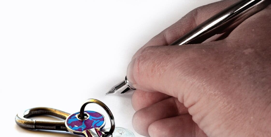 Hand with pen and keys