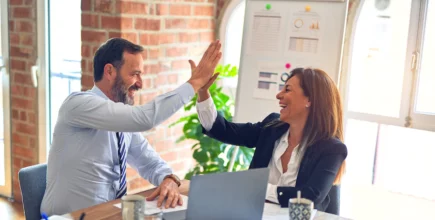 Team members high fiving in the office