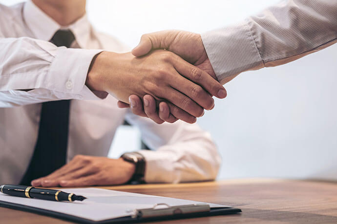 Estate broker agent and customer shaking hands after signing contract documents for realty purchase mortgage loan approval