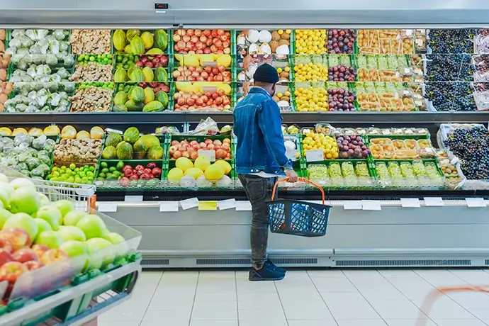 At the Supermarket: Happy Black Stylish Guy with Shopping Basket Shopping for Organic Fruits and Vegetables in the Fresh Produce Section of the Store.