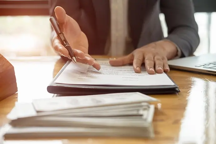 Close up business man reaching out sheet to sign.