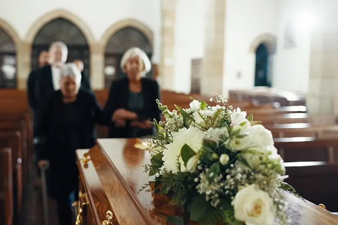 Funeral, church and people with coffin for goodbye, mourning and grief in memorial service. Depression, family and sad senior women with casket in chapel for greeting, loss and burial for death