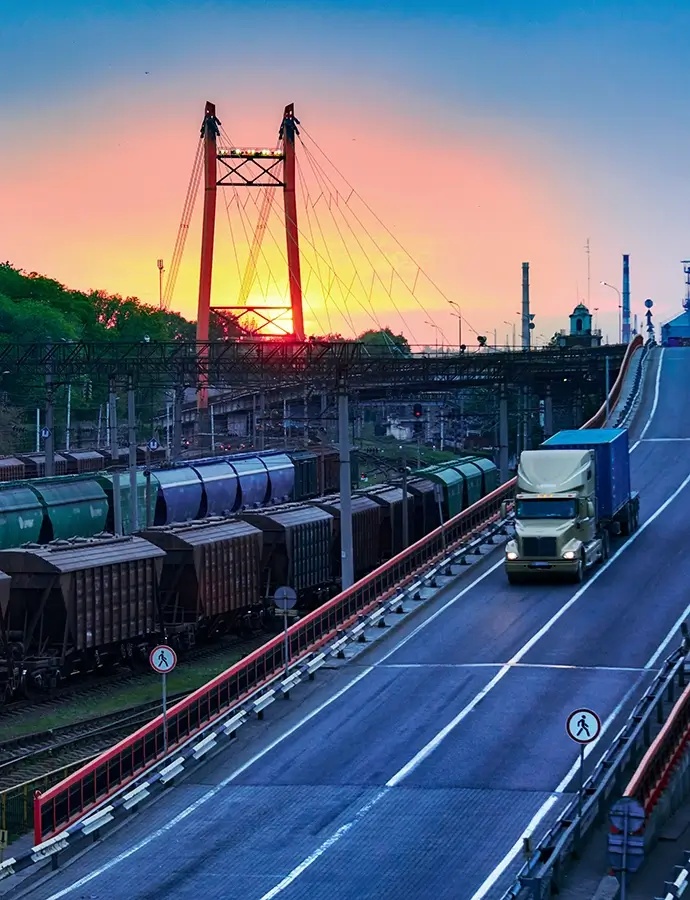 truck with container rides on the road, railroad transportation, freight cars in industrial seaport at sunset